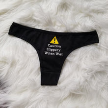 Load image into Gallery viewer, Caution Slippery When Wet text with caution sign above on a black thong