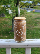 Load image into Gallery viewer, Glass beer can with white hearts decorating the glass. Shown with bamboo lid with straw hole and a straight glass straw.