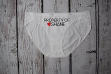 Load image into Gallery viewer, Women&#39;s white bikini underwear with the text property of Shane with a red heart next to the name. Text is black.
