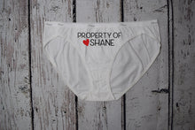 Load image into Gallery viewer, Women's white bikini underwear with the text property of Shane with a red heart next to the name. Text is black.