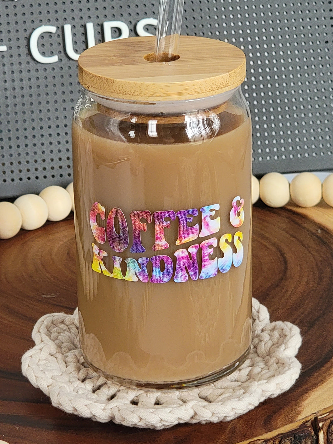 16oz glass can with Coffee & Kindness Decal in a tie dye color. Shown with bamboo lid and glass straw.