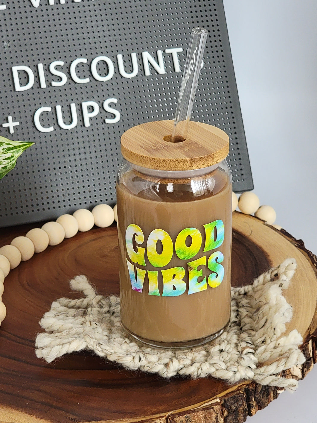 Good Vibes Only glass coffee cup in tie dye decal. Shown with optional bamboo lid and glass straw.
