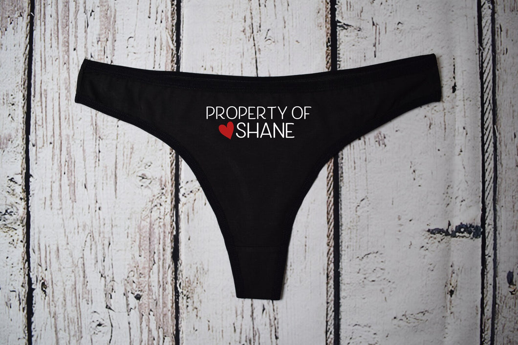 Black thong with property of design with heart and name